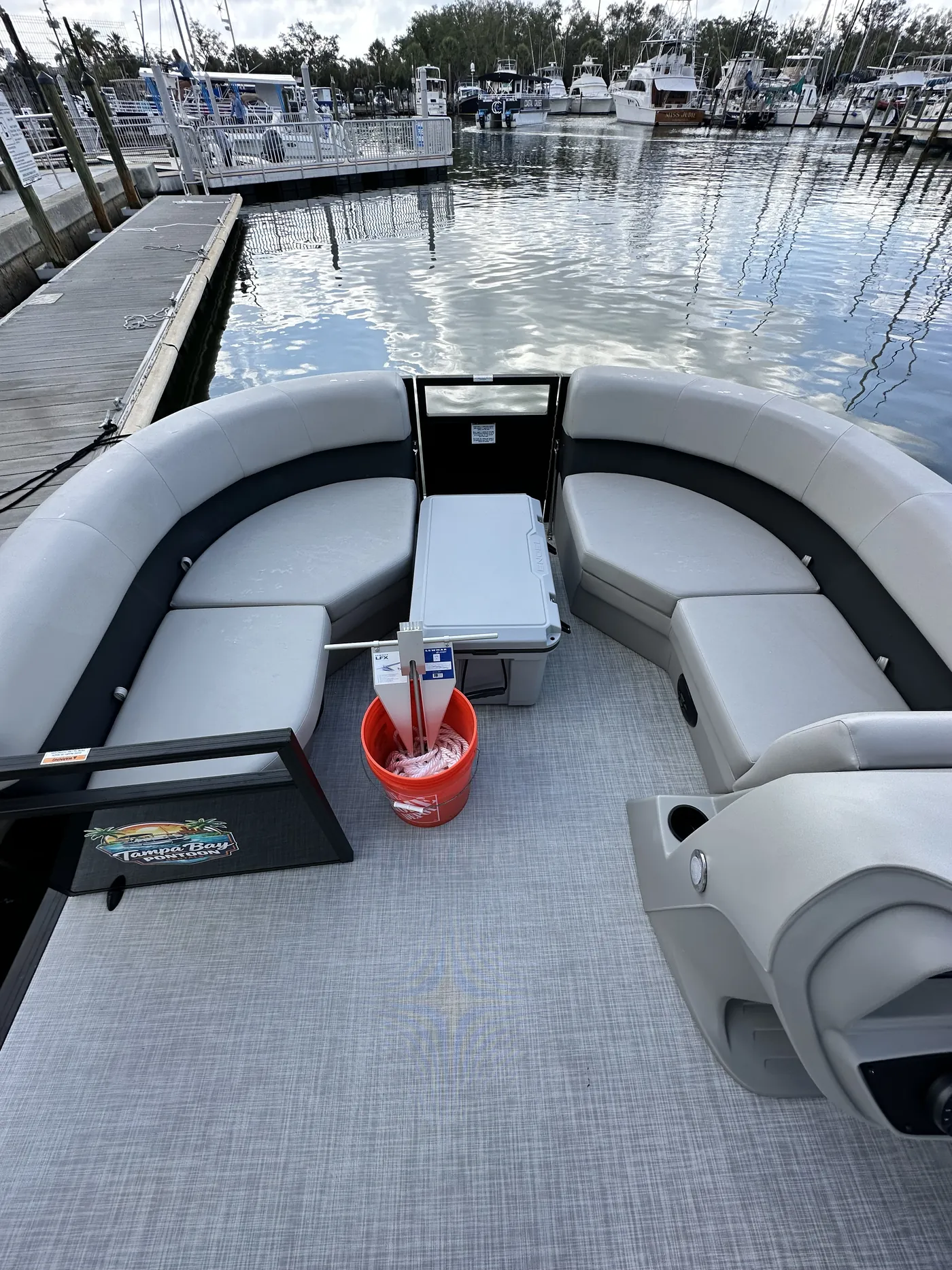 Overhead view of the pontoon deck at the dock showing the bow lounge seating and cooler