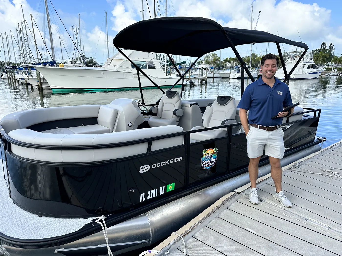 A Tampa Bay Pontoon Rentals staff member on the dock beside the 2026 TriToon before a rental