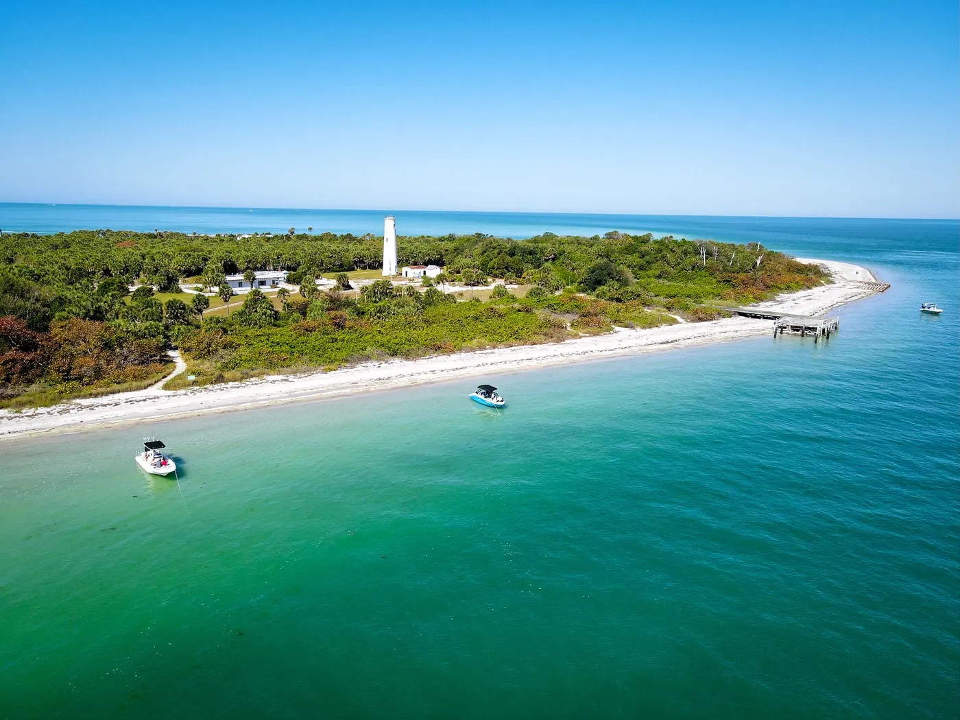 Aerial view of Egmont Key with its lighthouse, white sand beach and boats anchored offshore