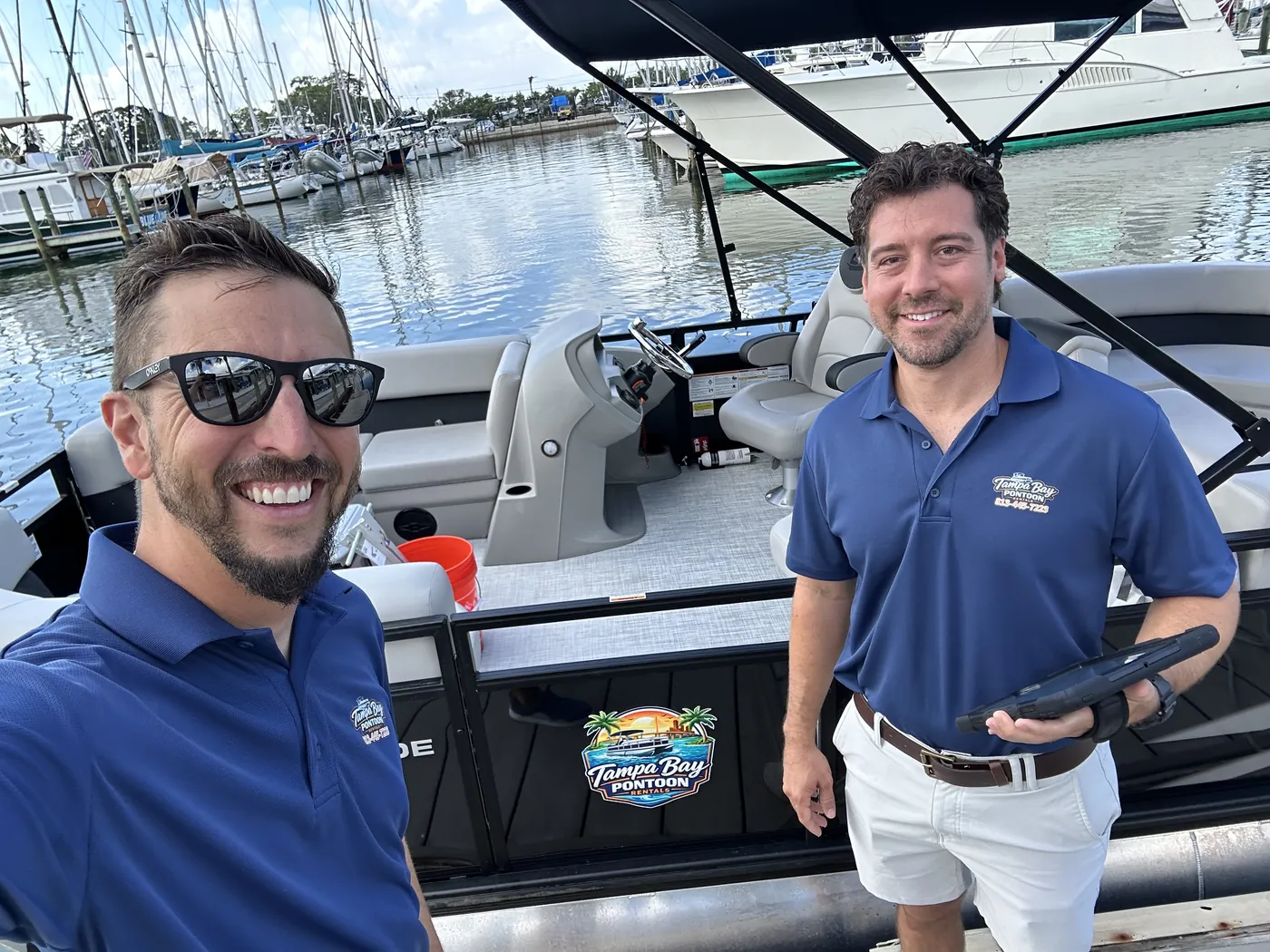 Two Tampa Bay Pontoon Rentals team members aboard the pontoon at the Gulfport marina