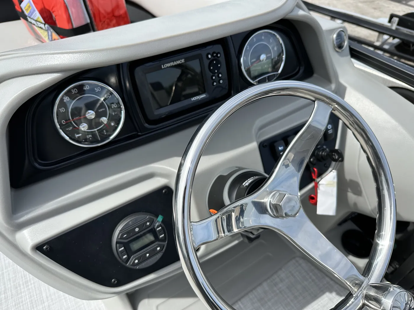 Close view of the pontoon steering wheel, gauges and stereo controls